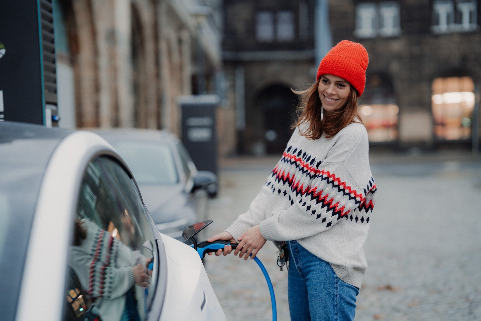 A woman charging an electric car.